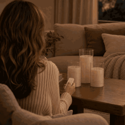 Woman switches on the LED candle set with the remote control from the sofa