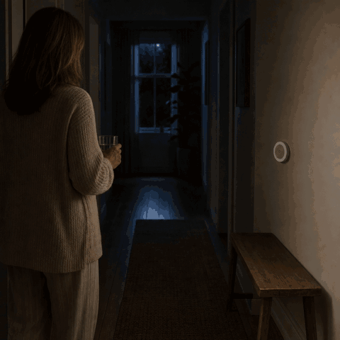 Woman enters the dark hallway and the LumiBeam night light turns on via motion sensor